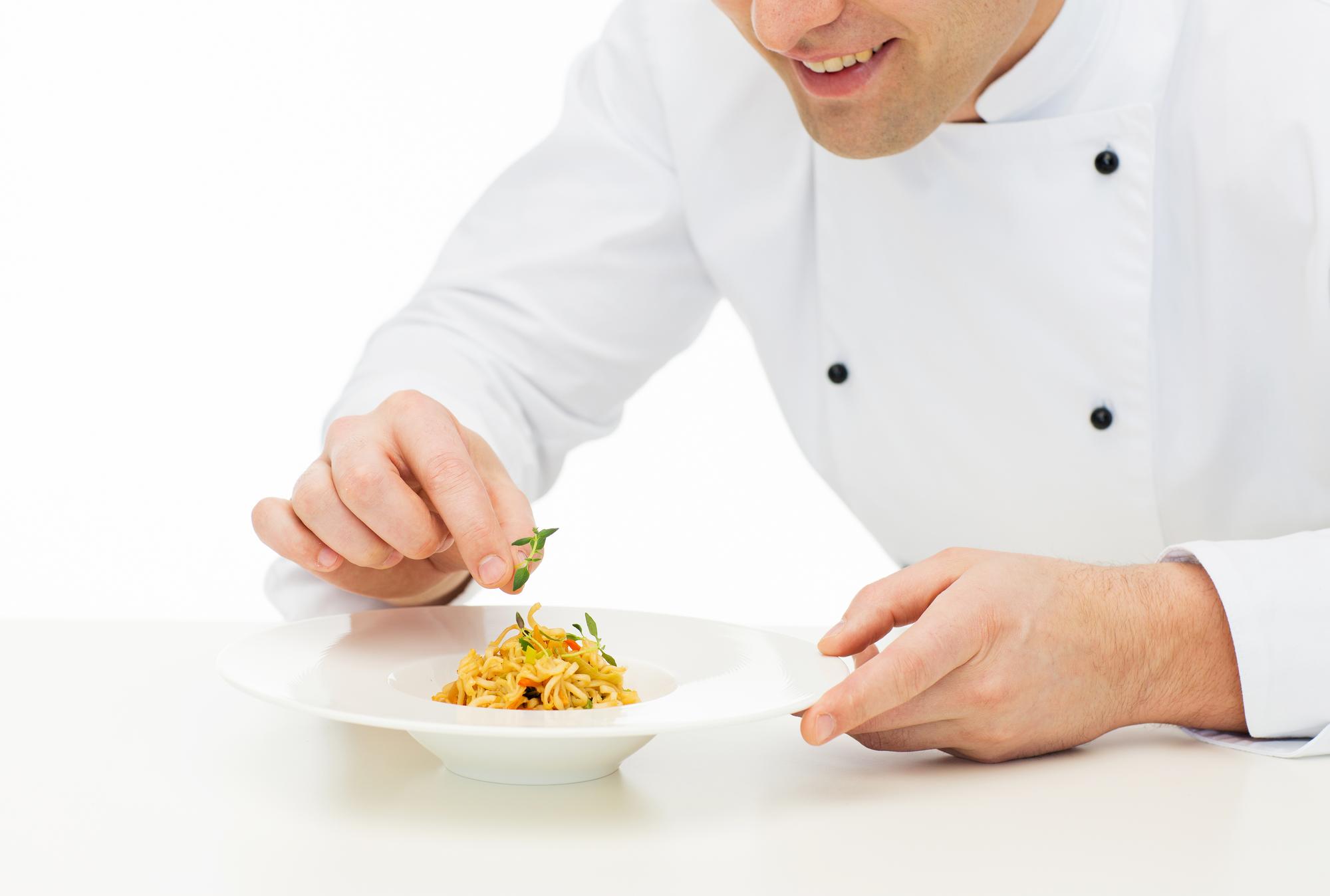 Chef plating a simple dish in a home kitchen